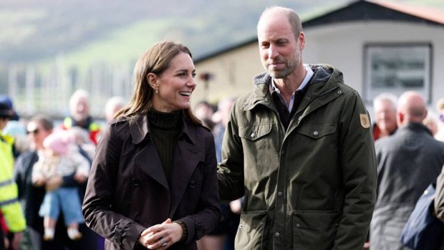 Prince William and Princess Kate get their hands dirty at the beach during horizontal rain