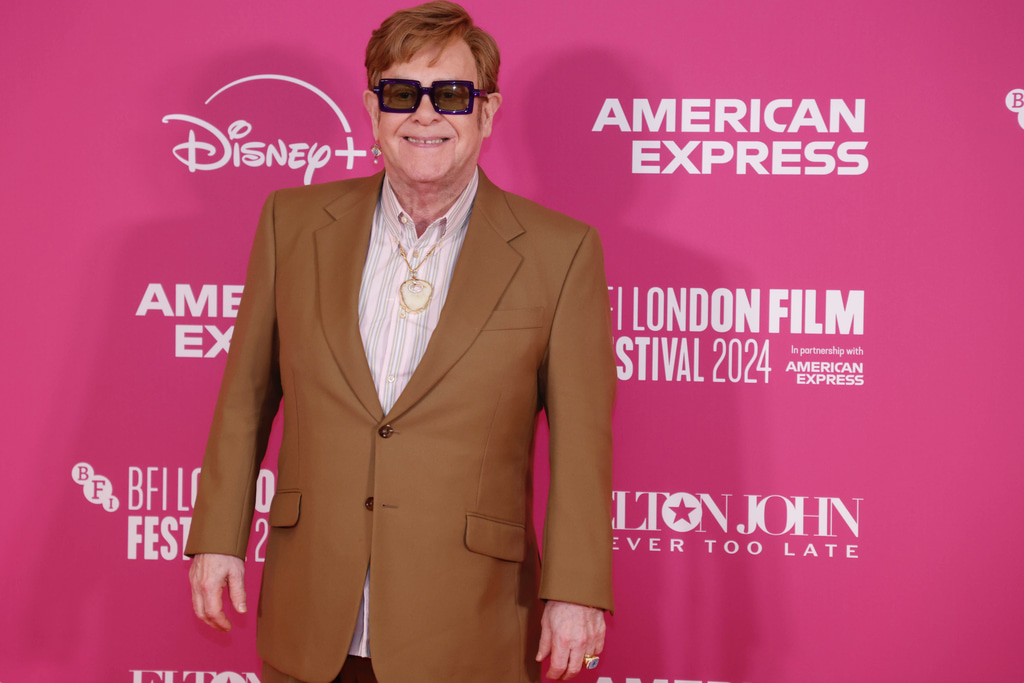 Elton John in a brown suit