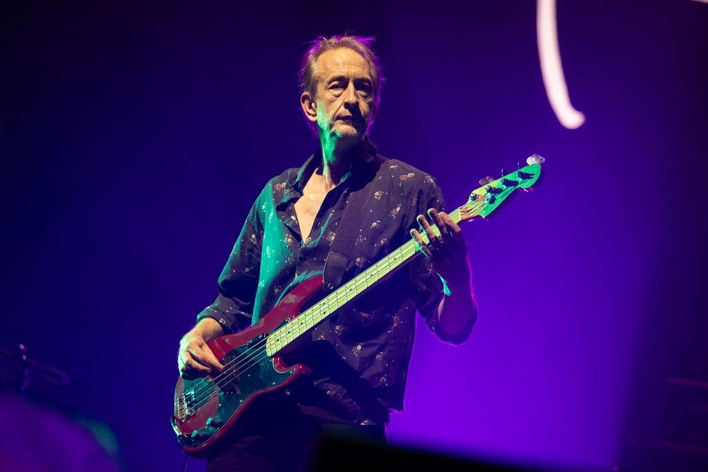 Mat Osman playing bass guitar on stage