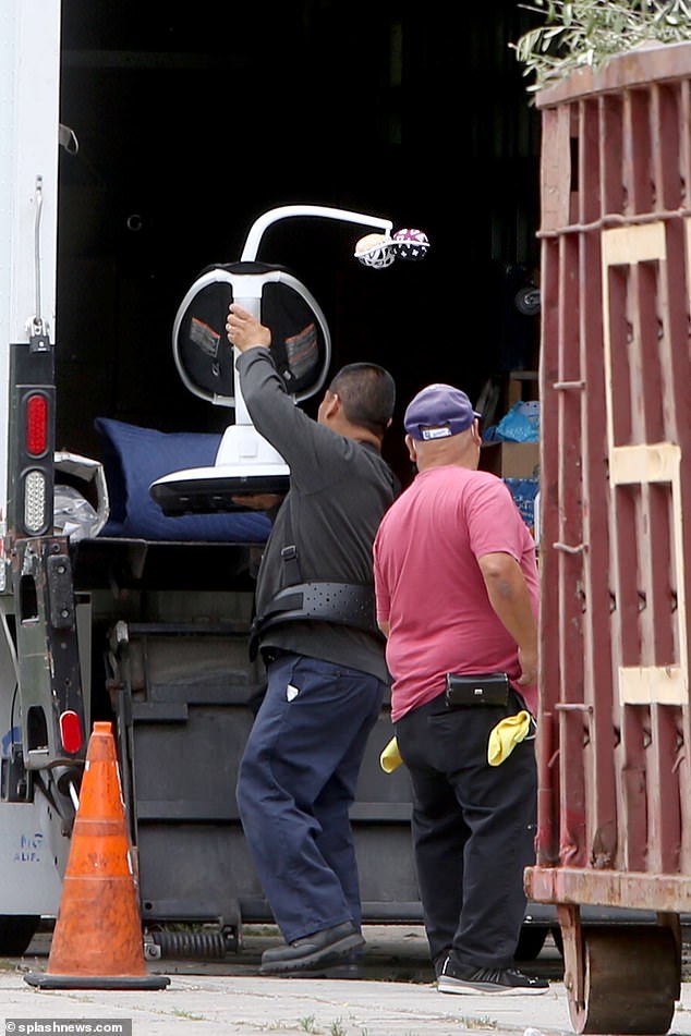 Boxes labelled 'wardrobe,' a baby chair and pink cushions were just some of the possessions seen being moved from the luxury home