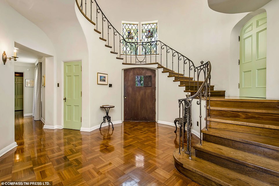 Many of the home's original romantic features remain, including a grand spiral staircase in the polished wood foyer