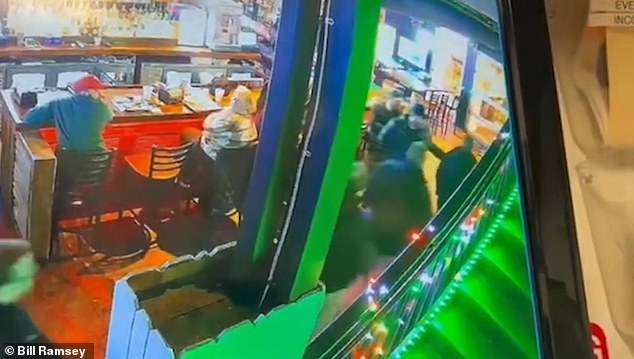 Young extends his arm appearing to bar the path of the first agent, but doesn't touch him