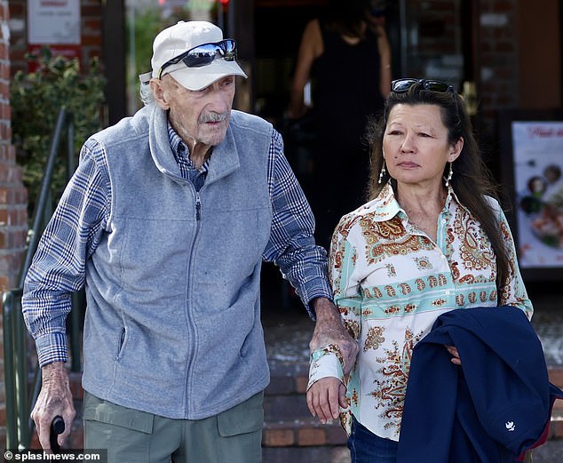 Hackman, who turned 94 in January, was dressed perfectly for a casual day out, sporting a gray fleece sweater over a casual plaid shirt, outdoor green pants, and black sneakers