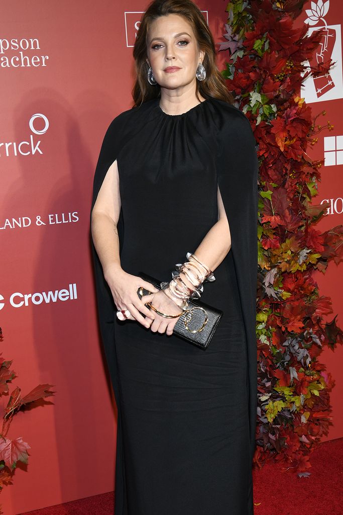 Drew Barrymore in a black dress with a red background