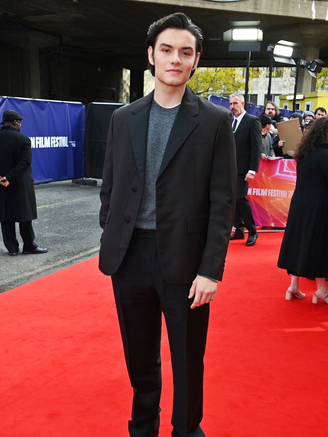 Louis Partridge in a black suit