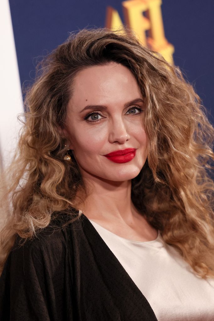 actress posing on red carpet with curly hair