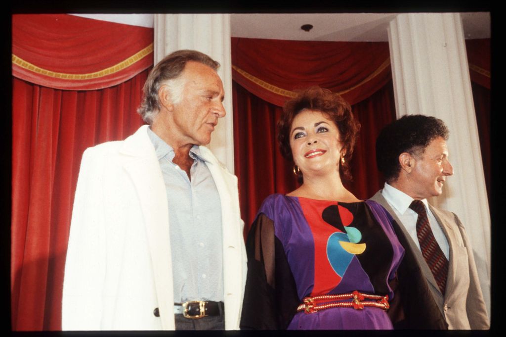 Richard Burton in a white suit and Elizabeth Taylor in a patterned dress