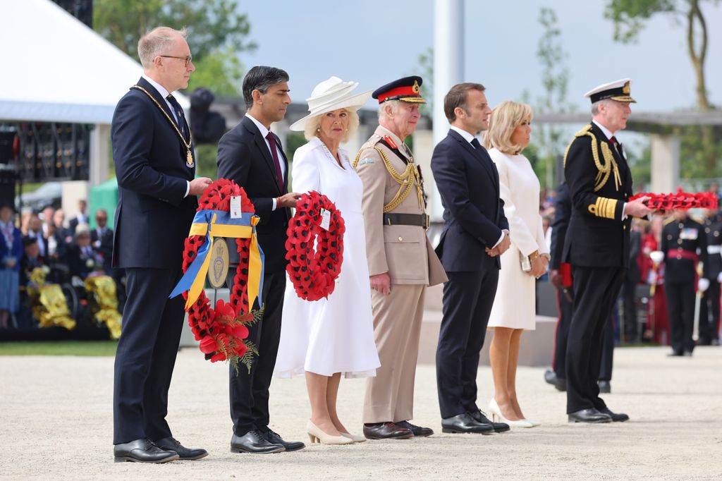 line of people holding red poppy wreaths