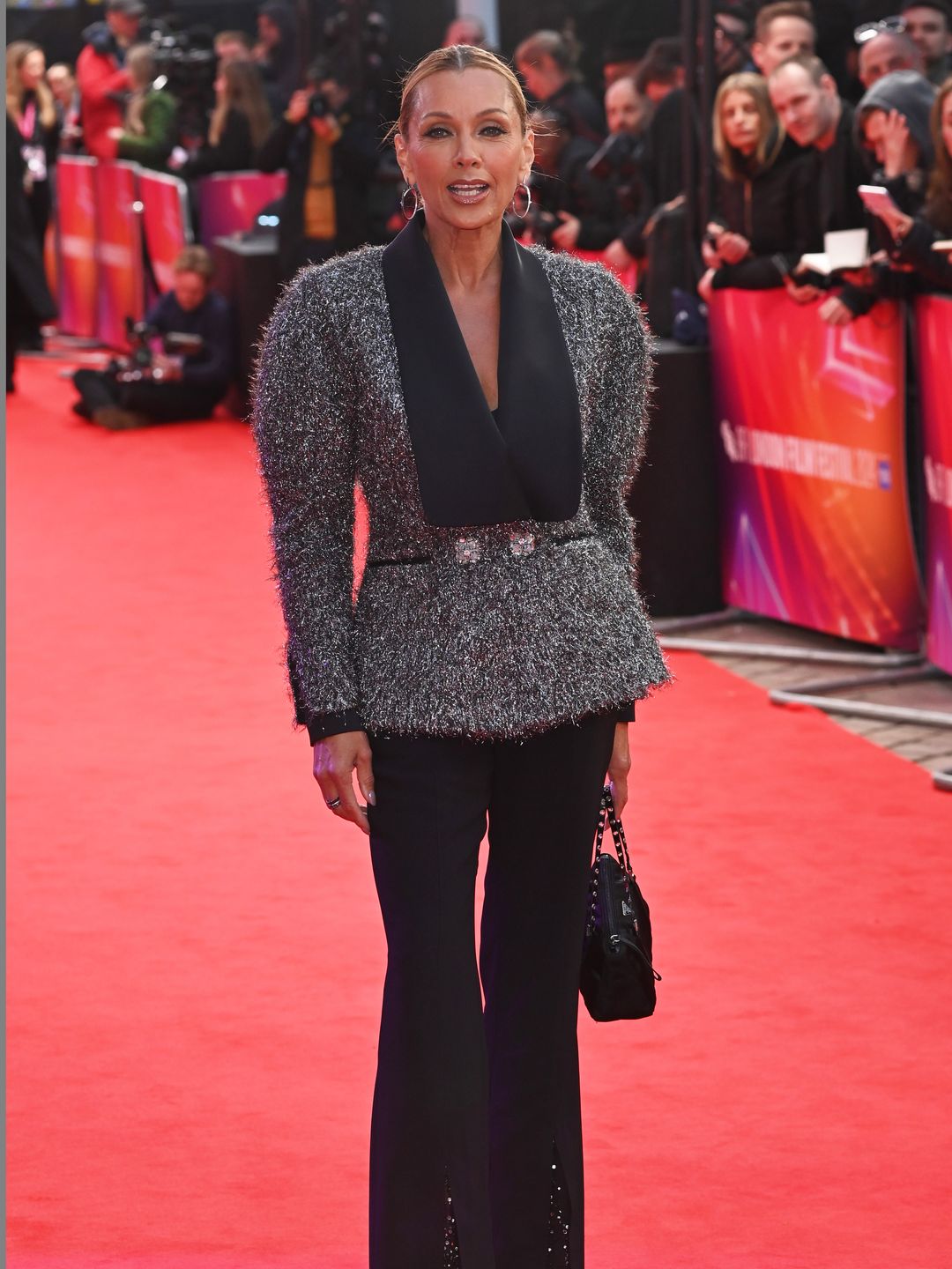 Vanessa Williams in a grey jacket and black trousers