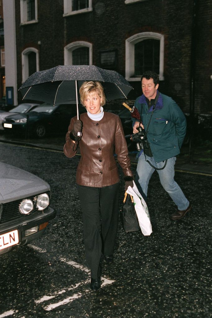 Duchess Sophie in brown leather jacket holding umbrella