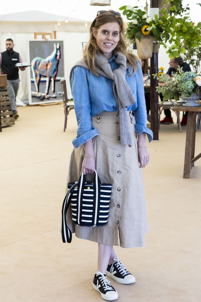 Princess Beatrice smiles in denim shirt and beige skirt