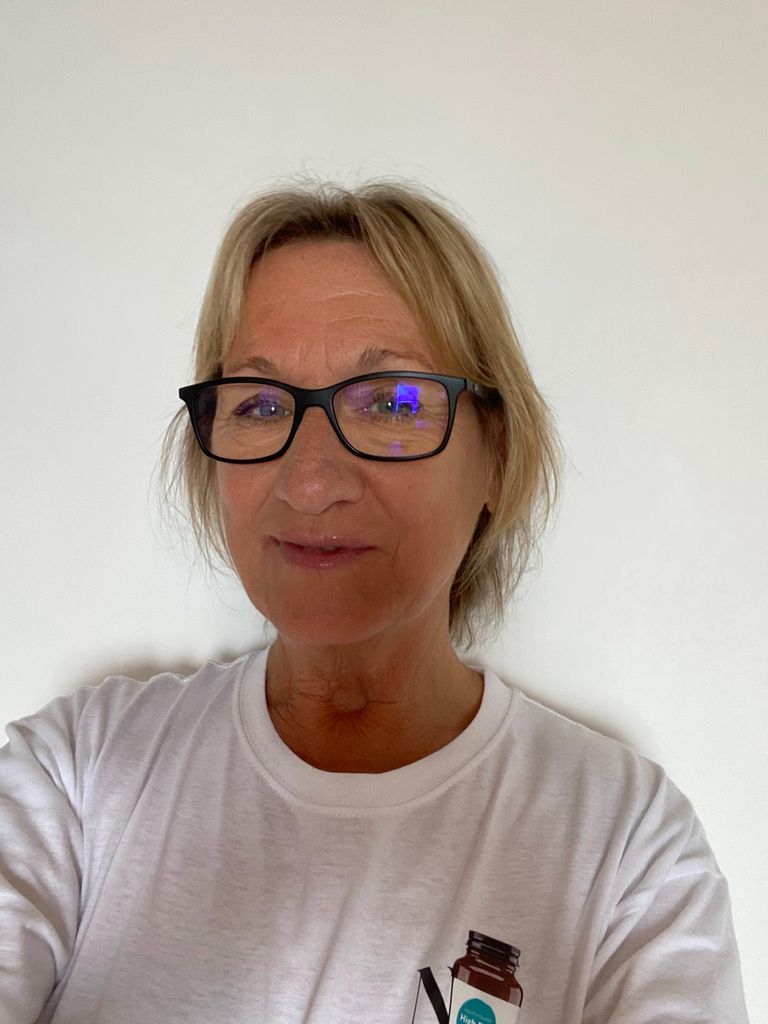 woman smiling taking a selfie in a white top