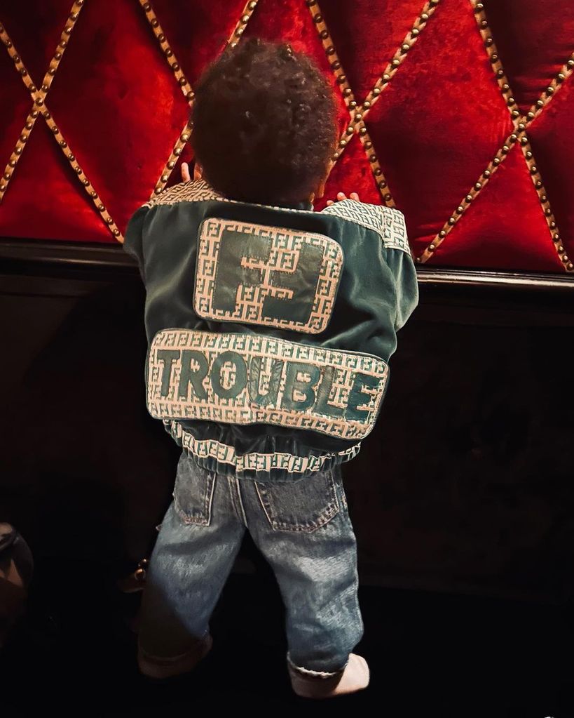 RZA from the back wearing a Fendi jacket with the word 'TROUBLE' on it