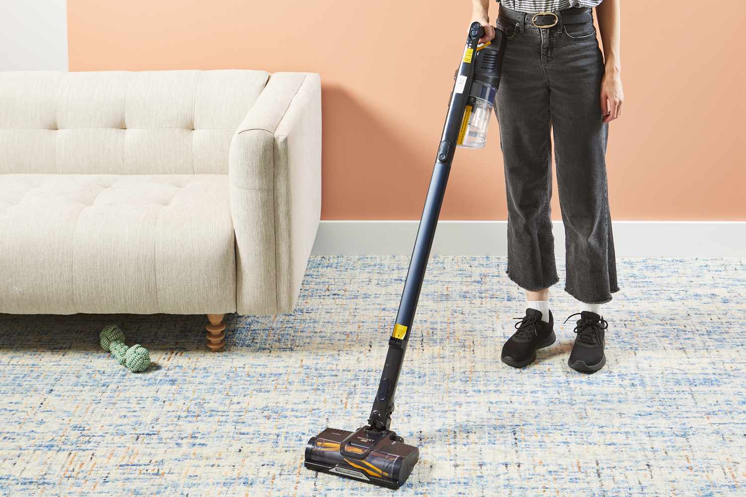 Person using Shark Pet Pro Cordless Stick Vacuum Cleaner to clean a rug