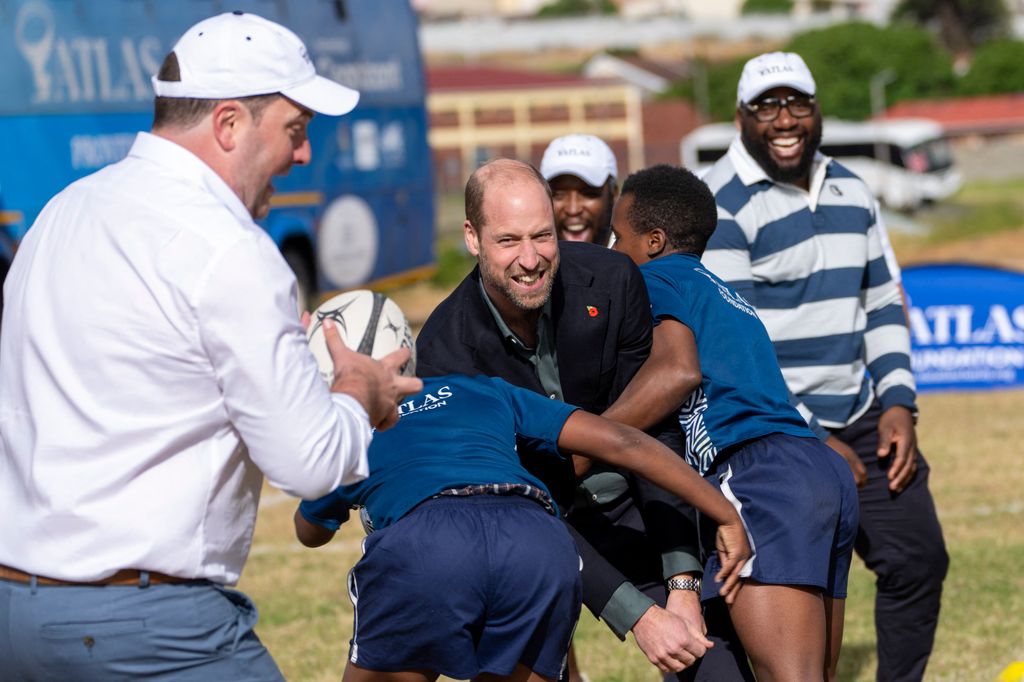 Prince William is tackled while playing rugby 