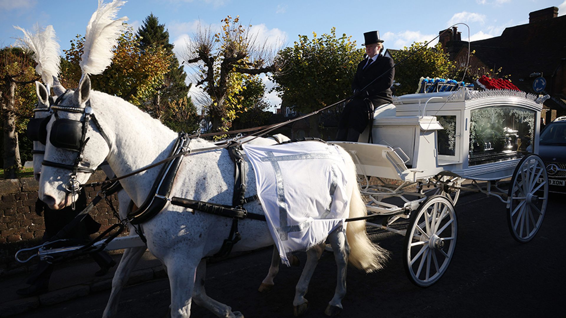 A horse drawn hearse arriving at the funeral of Liam Payne