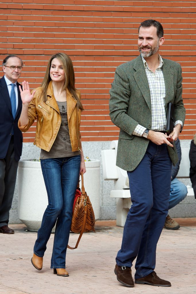 Princess Letizia waving with felipe in jeans with unexpected cowboy boots and a leather jacket in 2013