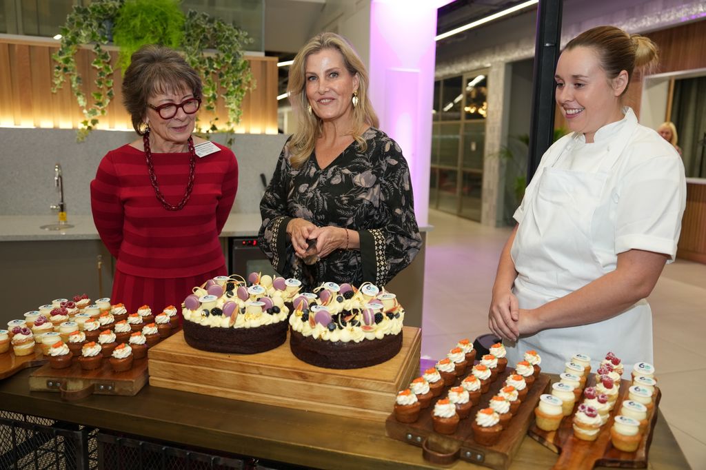 three woman with cakes on table 