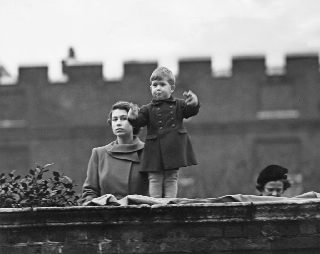 Prince Charles standing on the wall at Clarence House with Princess Elizabeth in 1950