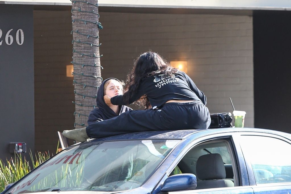 Shiloh Jolie's friend brushes a piece of hair from her face