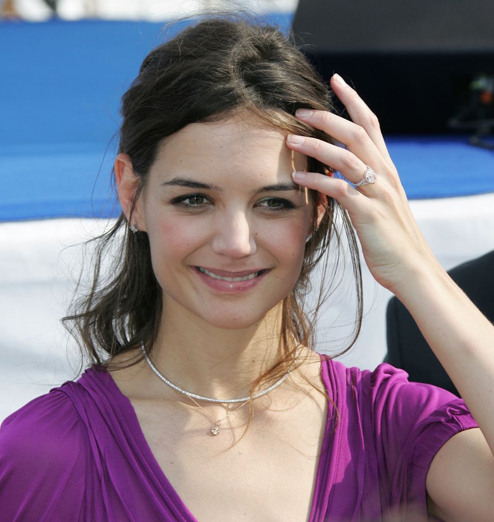 Katie Holmes holding hand to face 