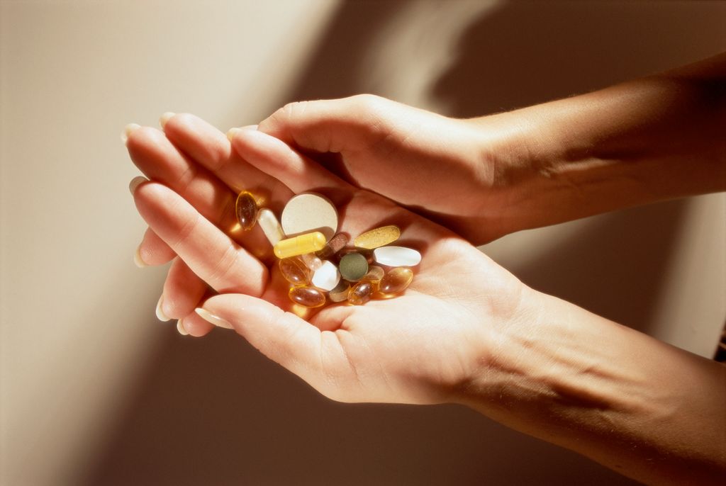 women holding a handful of supplements