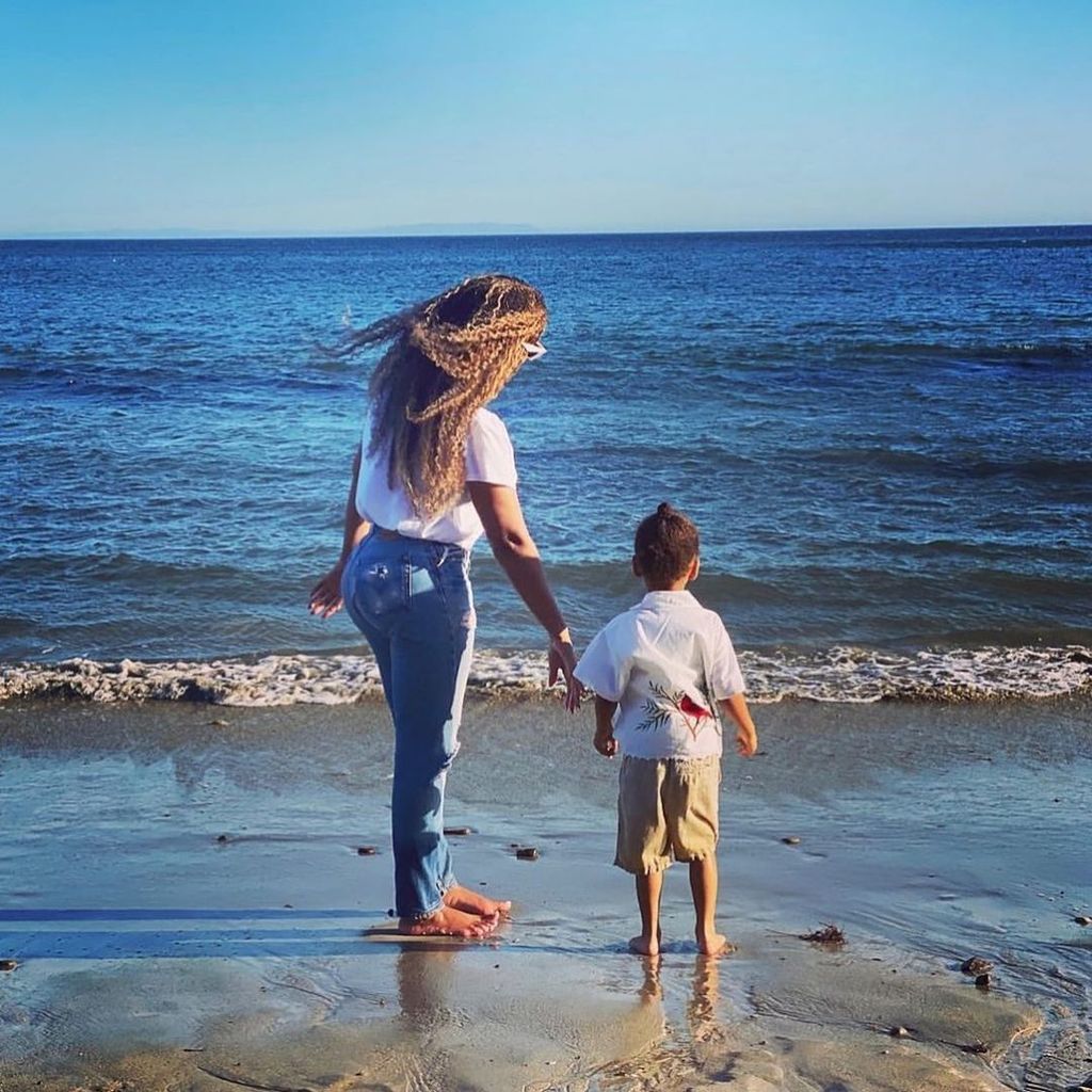 Beyonce stood on a beach with Sir, their backs are to the camera