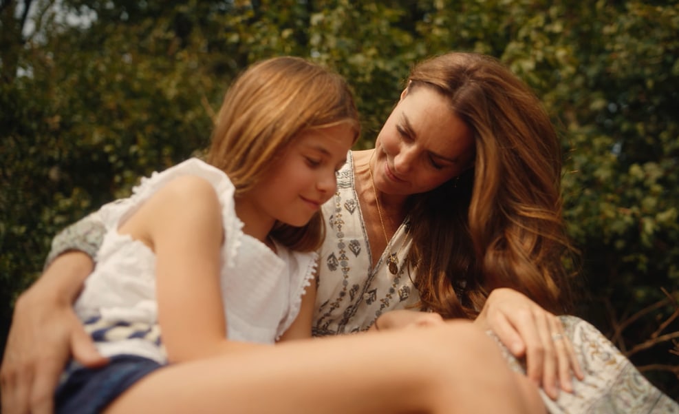 Kate with her arm around Princess Charlotte