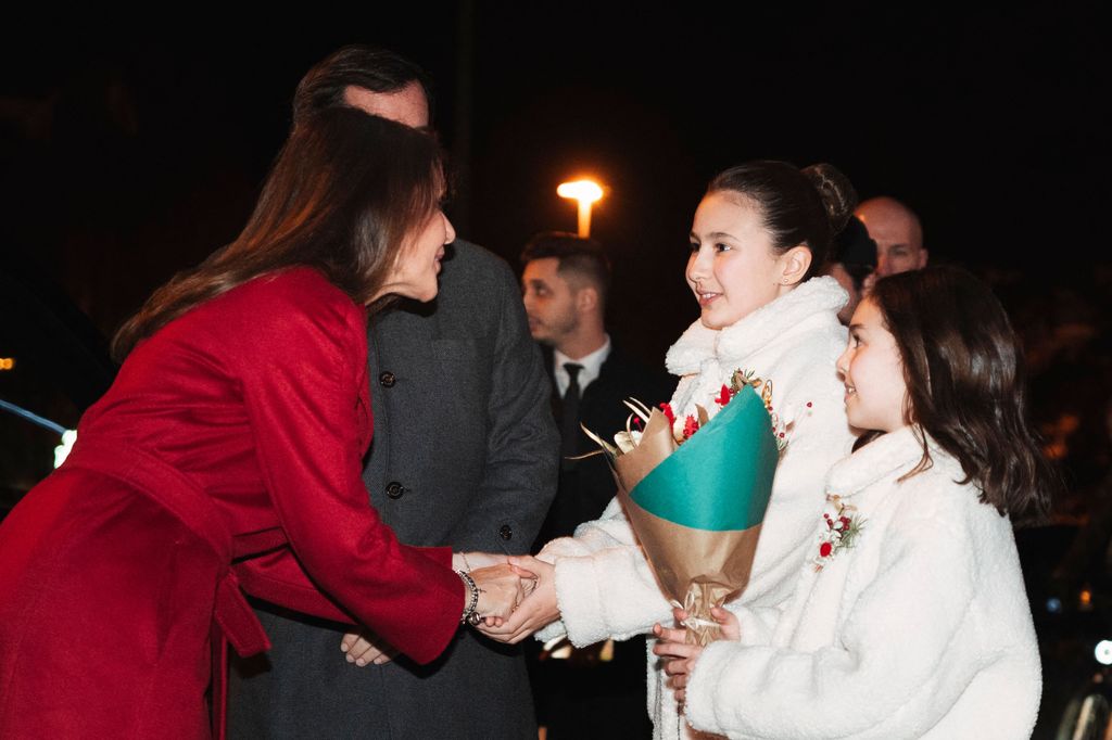 A photo of Princess Marie shaking hands with a young girl