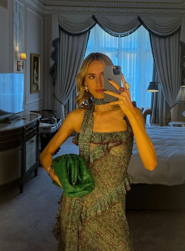 Mia Southgate posing inside a hotel home in a green bejewelled dress