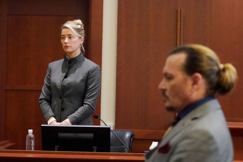 Amber Heard (L) and Johnny Depp watch as the jury leaves the courtroom at the end of the day at the Fairfax County Circuit Courthouse in Fairfax, Virginia, May 16, 2022