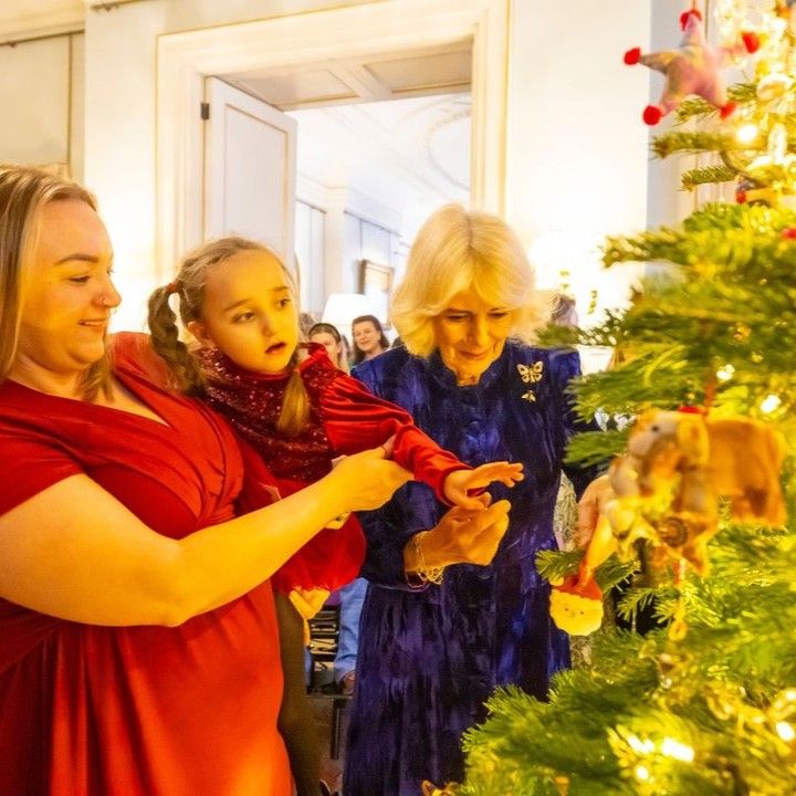 Queen Camilla, a woman and a child decorating a Christmas Tree at Clarence House