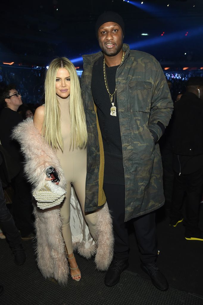 Khloe and Lamar Odom smiling at the camera in a dark room