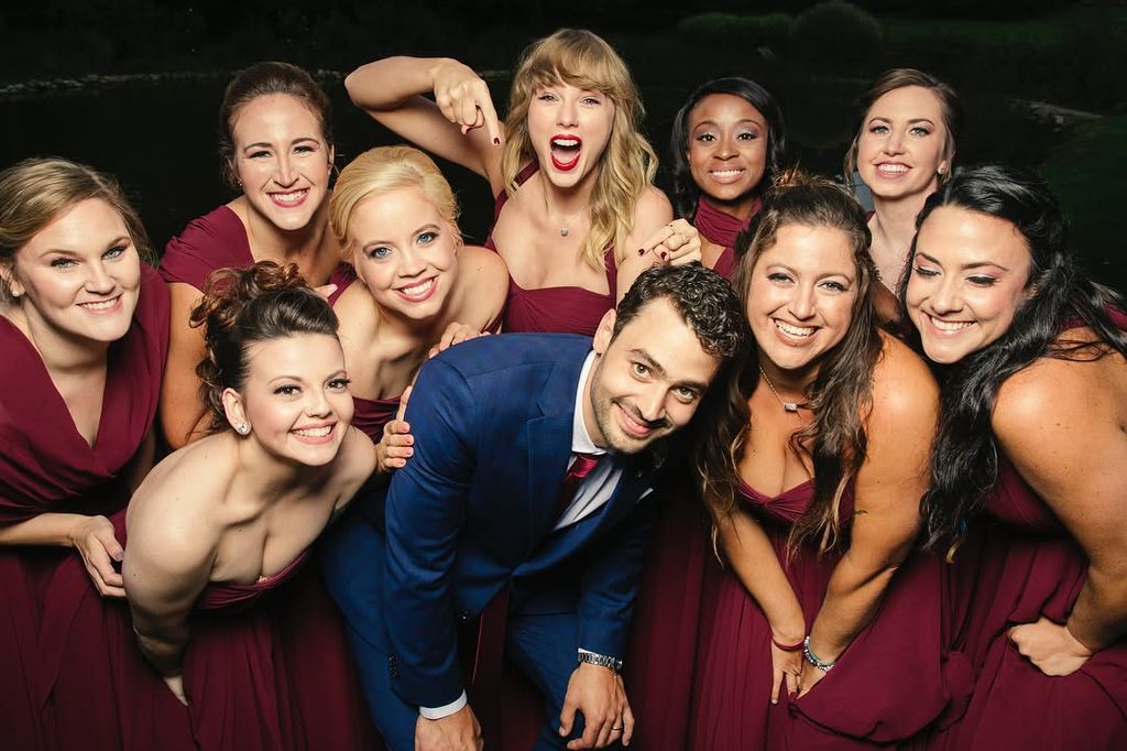 Taylor Swift and a group of women in burgundy dresses 