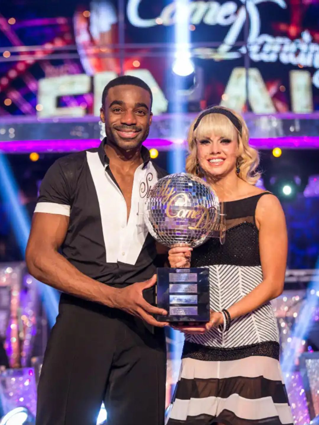 Ore Oduba and Joanne Clifton standing with the Glitterball Trophy