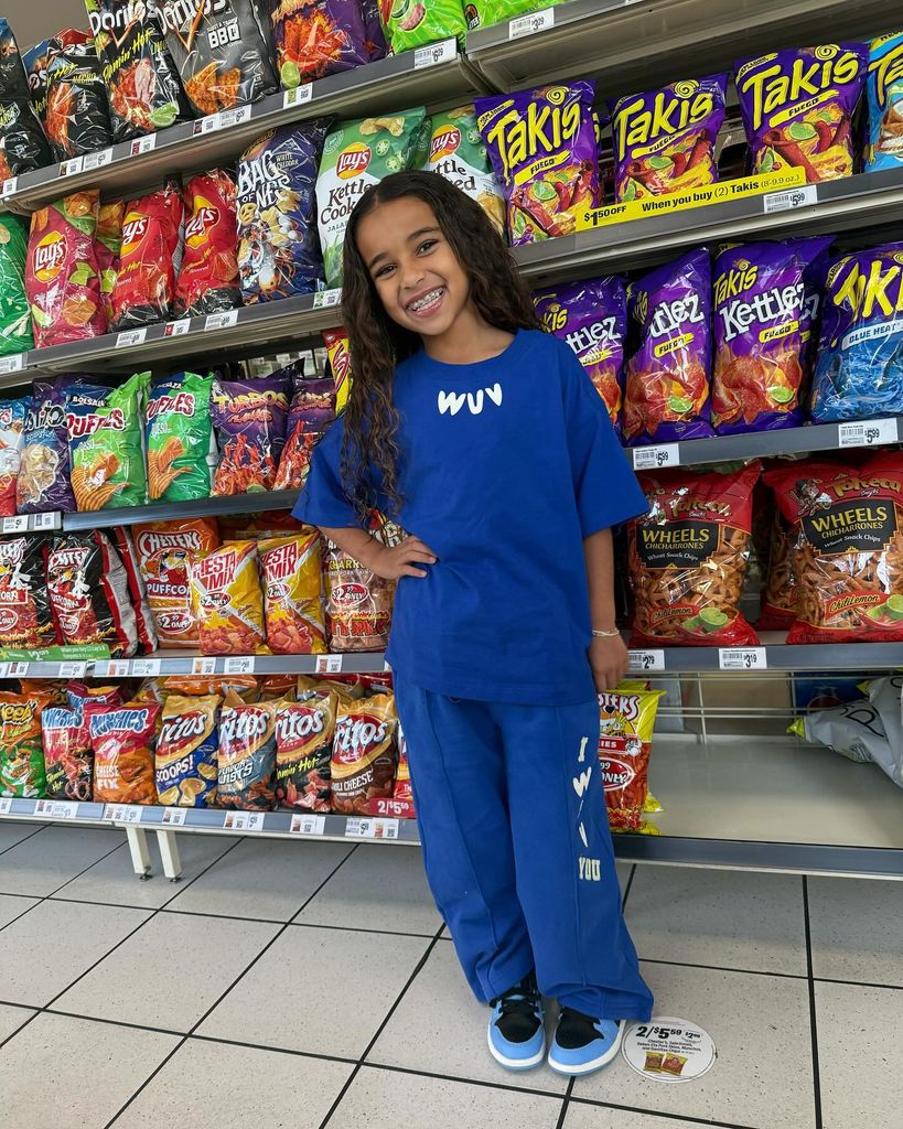 Dream Kardashian posing in front of crisps in the supermarket