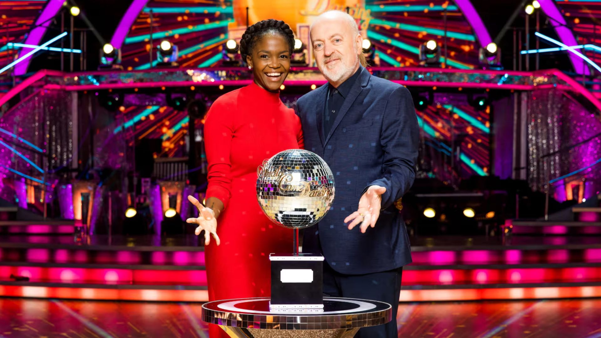 Oti Mabuse and Bill Bailey standing in front of the Glitterball Trophy