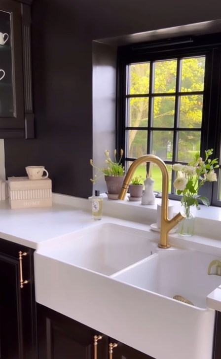 black kitchen featuring a farmhouse sink