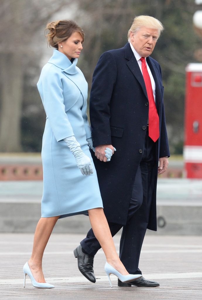 President Donald Trump and Melania Trump in blue walk hand in hand