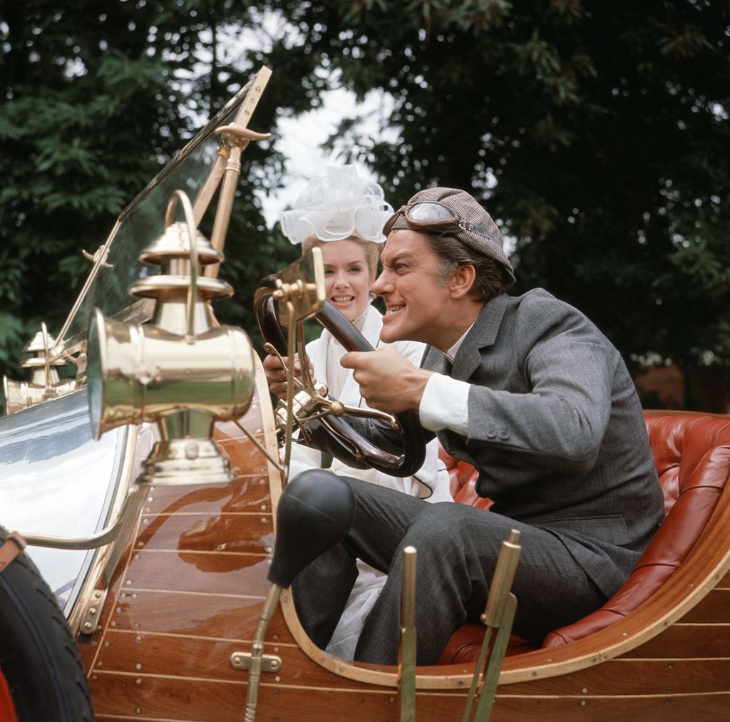 American actor Dick van Dyke and actress Ann Howes with the car which co-stars in their film 'Chitty Chitty Bang Bang' during production at Pinewood Studios. Dick Van Dyke plays Caractacus Potts with Sally Ann Howes as Truly Scrumptious. July 1967.