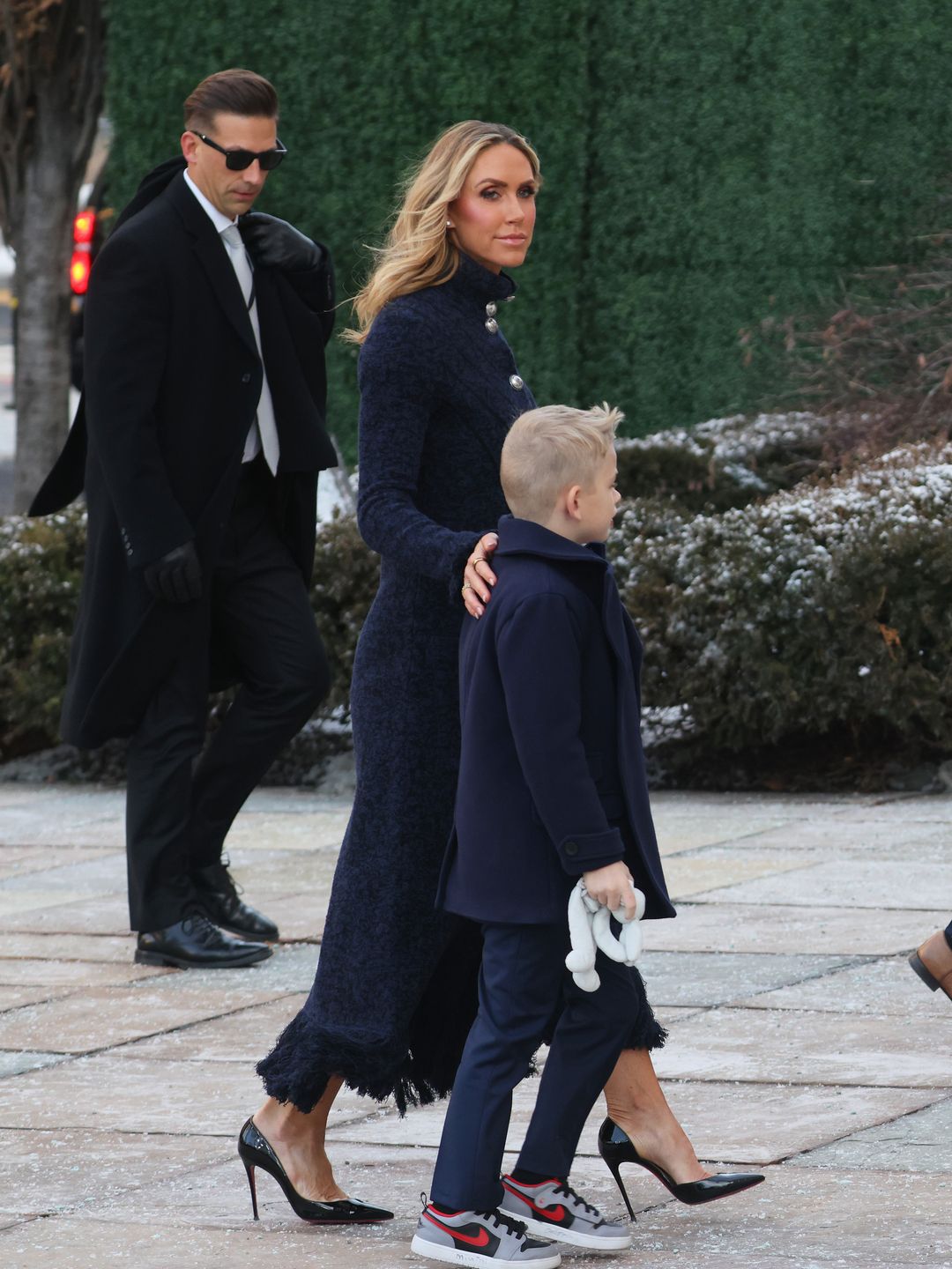 Lara Trump on her way to the Inauguration with her children and Eric Trump: she radiated timeless elegance in a long, navy textured coat adorned with striking silver buttons.