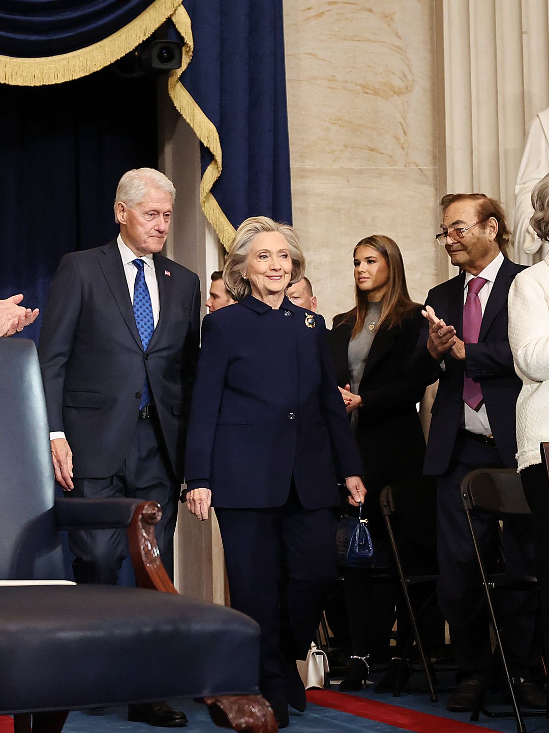 Hillary Clinton wears her signature pantsuit style, stepping out in a deep navy ensemble topped off with a sparkly brooch at The Inauguration of President Trump. 