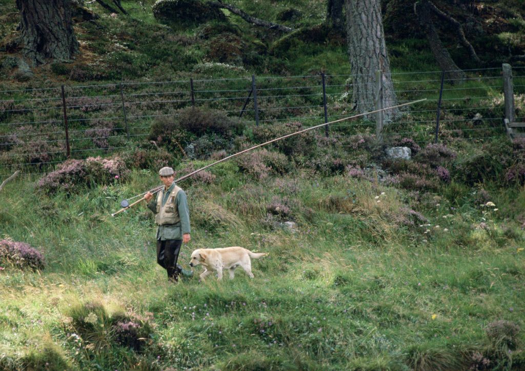 King Charles with a fishing rod and his dog Harvey