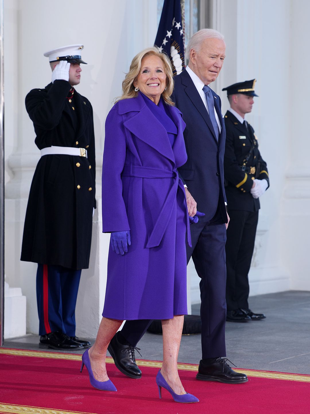 Jill Biden lit up the scene in a vibrant cobalt-blue coat and matching heels. The belted waist added a flattering, feminine touch. She wals to the Inauguration on a red carpet with Joe Biden. 