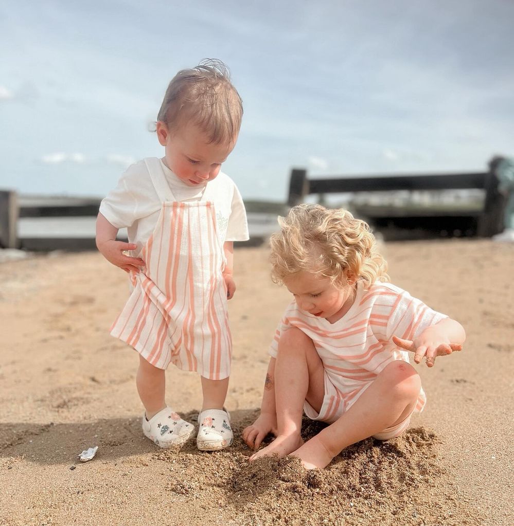 two young sisters playing on beach 