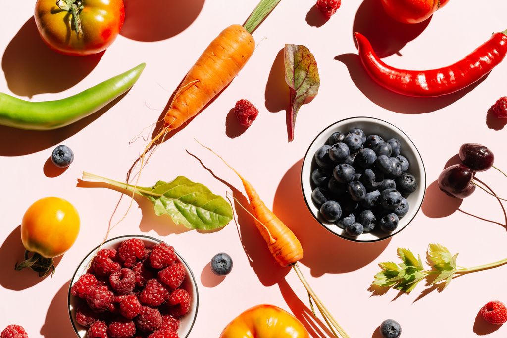 Pattern of variety fresh of organic berry fruits and vegetables and healthy vegan meal ingredients on pink background.