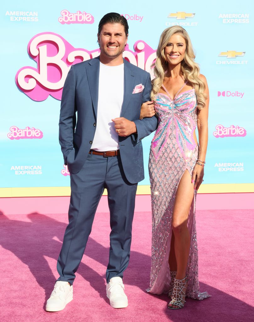 Christina and her husband Josh smiling arm in arm at the premiere