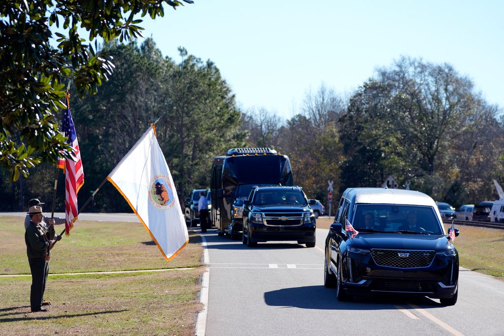 Members of the National Park Service watch as the hearse containing the casket of former President Jimmy Carter, pauses at the Jimmy Carter Boyhood Farm on January 4, 2025 