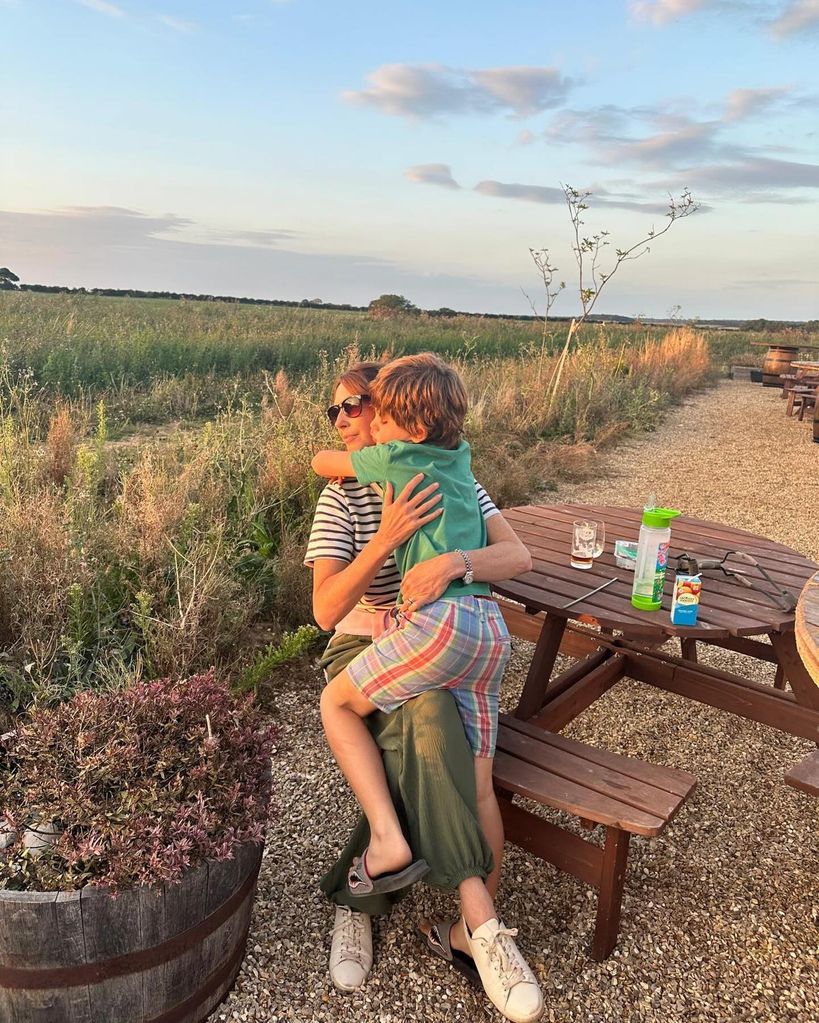 mother hugging son on wooden bench