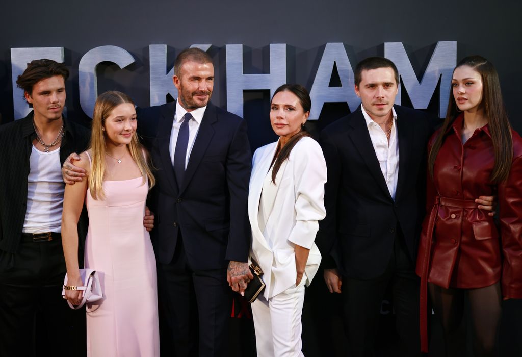 Victoria Beckham in a white suit with her son Brooklyn